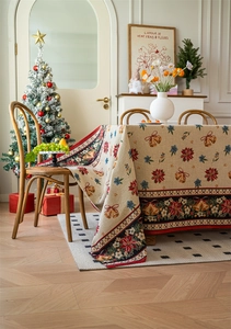 Close-up of woven Christmas tablecloth featuring bells and poinsettia patterns