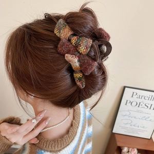 Close-up of retro tweed fabric hair claw clip in brown and yellow tones on hair