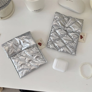 Close-up of heart and diamond quilted silver pouch bags for sanitary pads and earphones