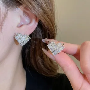 Elegante silberne Herzohrringe mit gesteppter Textur und Zirkonsteinen am Modell