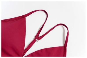 Détail d'un haut de yoga rouge foncé avec fines bretelles et anneaux en métal