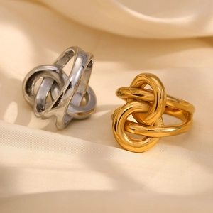 Bague double nœud minimaliste en finitions or et argent sur tissu en soie beige