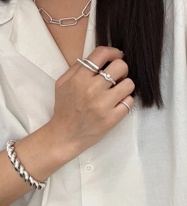 Close-up of minimalist S925 sterling silver chain necklace and geometric rings on a model