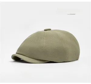 Detail view of light green newsboy cap with multi-panel stitching and top button