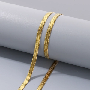 Macro detail of a 14k gold-plated stainless steel herringbone blade chain necklace