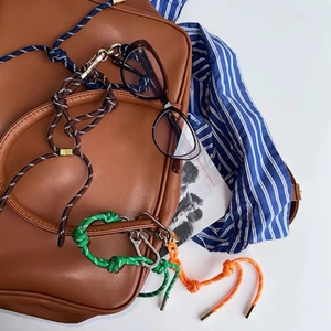 Detail van kleurrijke geweven nylon lanyards en hangers op bruine leren rugzak