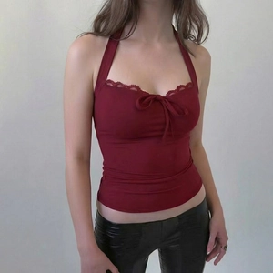 Detail of burgundy lace trim halter top featuring front tie-up design on model