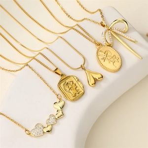 Close-up of five gold-plated necklaces featuring bow, heart, and portrait pendants