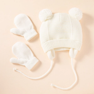 White knitted baby hat and mittens set with earflaps and pom poms for winter warmth