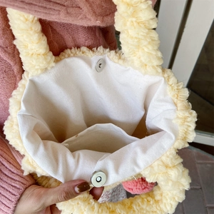 Detail of plush tote bag showing canvas lining, magnetic clasp, and inner pocket