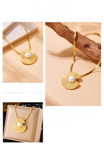 Detailed view of a gold-plated shell pendant with a square pearl on a sleek snake chain