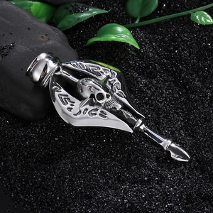 Macro shot of silver skull pendant with arrow texture on black background