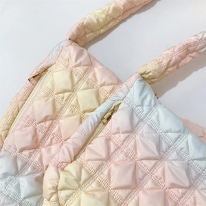 Detail of pink and blue gradient quilted cloud bags with padded straps and metal zippers