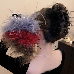 Detailed view of elegant feather hair claw clip with glass beads for messy bun hair styling