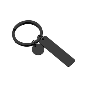 Macro shot of matte black stainless steel rectangular tag and round plate keychain