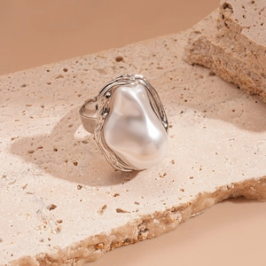 Detailed macro view of an irregular baroque pearl ring with liquid metal texture finish