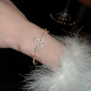 Close-up of pink zircon butterfly bracelet with rose gold plating on a model wrist