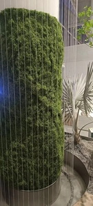 Detailed view of a green artificial moss landscape column with vertical white line accents