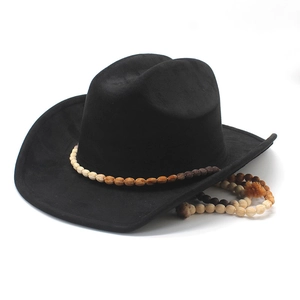 Detail of black cowboy hat with bohemian beaded band and tassel on white background