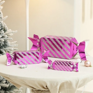 Three-piece set of purple and silver glitter candy-shaped Christmas gift boxes on a table
