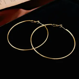 Grandes boucles d'oreilles créoles dorées minimalistes avec un design en fil mince
