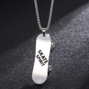 Gros plan du pendentif skateboard en argent avec gravure Skate Spirit et détails de la chaîne
