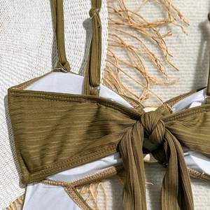 Gros plan du maillot de bain côtelé vert olive avec nœud frontal et anneau en bois