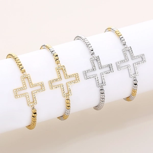 Détail de bracelets perlés avec croix ajourée et strass en finitions or et argent