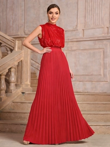 Detail of red sleeveless sequined bodice and high-waist pleated skirt on stone stairs