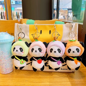 Cute panda plush keychains with fruit backpacks hanging on a canvas bag handle