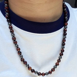 Close-up of men's beaded necklace with tiger eye and hematite stones on a neck
