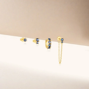 Detail of four-piece gold S925 silver earring set featuring elegant blue zircon stones