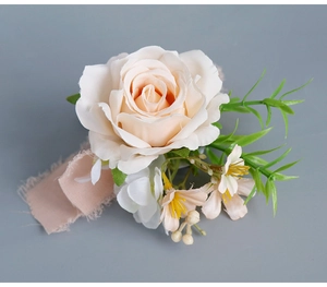 Gros plan de la boutonnière rose en soie avec feuilles vertes et ruban en mousseline