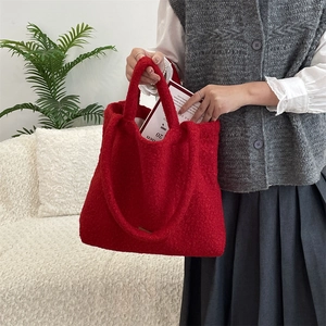 Dettaglio della borsa tote in pile rosso con texture morbida e design spazioso del manico