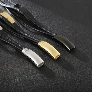 Dettaglio di bracciali in pelle intrecciata con chiusure in acciaio argento, oro e nero
