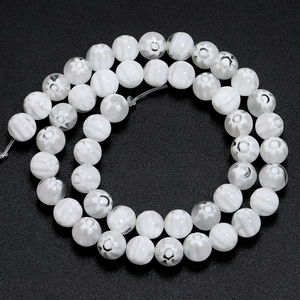 Macro view of white millefiori glass beads with floral patterns for DIY jewelry