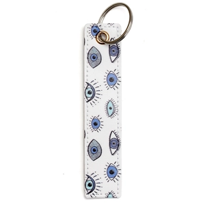 Detailed view of white faux leather keychain featuring vibrant blue evil eye pattern prints