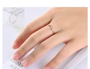 Detail of wavy titanium steel rings in rose gold and silver finish for women