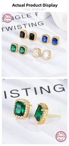 Macro detail of S925 sterling silver square halo earrings with emerald green cubic zirconia