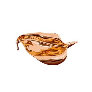 Polished rose gold leaf brooch with irregular smooth metal surface on white background