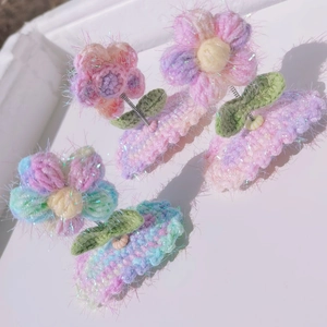 Hand-knitted puff flower hair clips with spring support in pink and rainbow gradient yarn