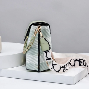 Mini green crossbody bag with white plaid design and graffiti print wide strap