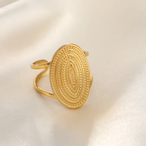 Detail of gold hammered stainless steel oval ring with embossed sunburst texture