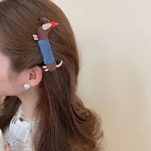 Handmade brown polka dot dachshund hair clip with blue denim outfit on a model
