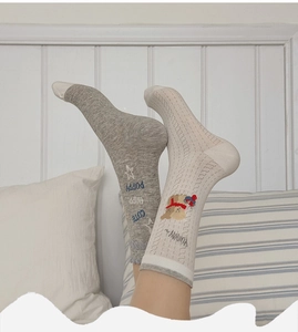 Close-up of gray cotton socks featuring a cute puppy pattern and breathable knit texture