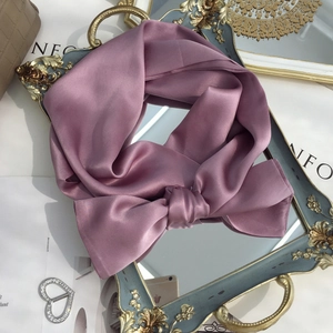 Close-up of a purple silk scarf tied in a bow on a vintage mirror with elegant decor