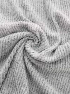 Close-up of light grey ribbed knit fabric showing soft texture and vertical stripe texture