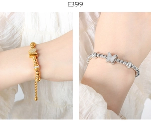 Detail of beaded butterfly charm bracelet in gold and silver finish with adjustable clasp