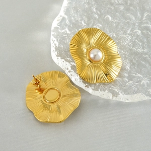 Vintage gold wavy earrings with radiant texture and center pearl detail