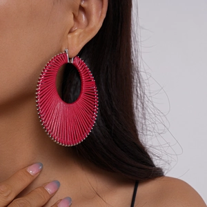 Close-up of woven rose red thread on large oval geometric hoop earrings for women
